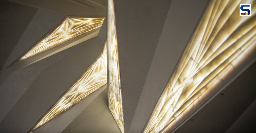 Four surfaces (three walls and a ceiling) are mathematically sub-divided into triangles of varied sizes and angles through computational methods that allow optimization of material and construction time.